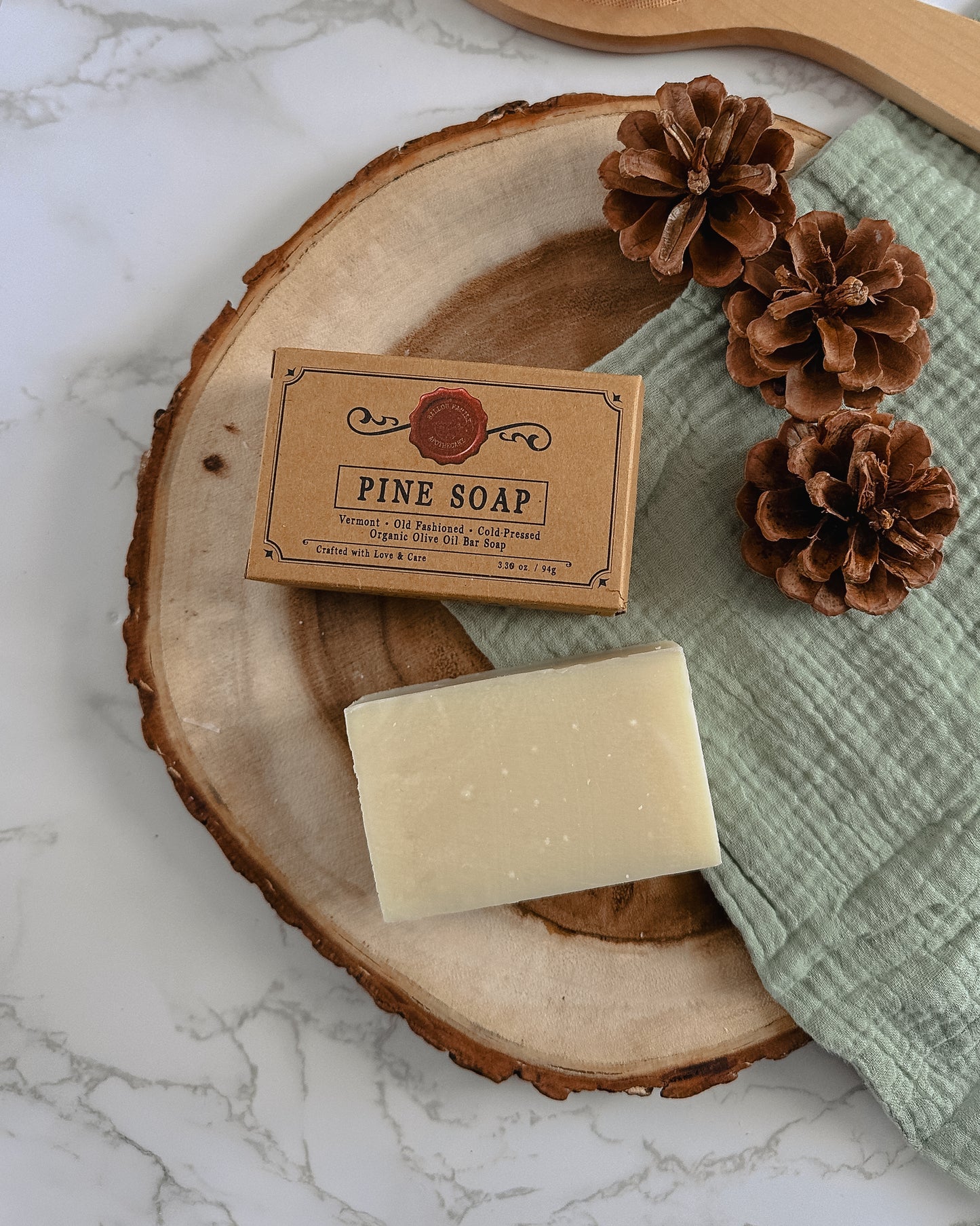 Box of Cold-Pressed Pine Soap next to natural bar soap