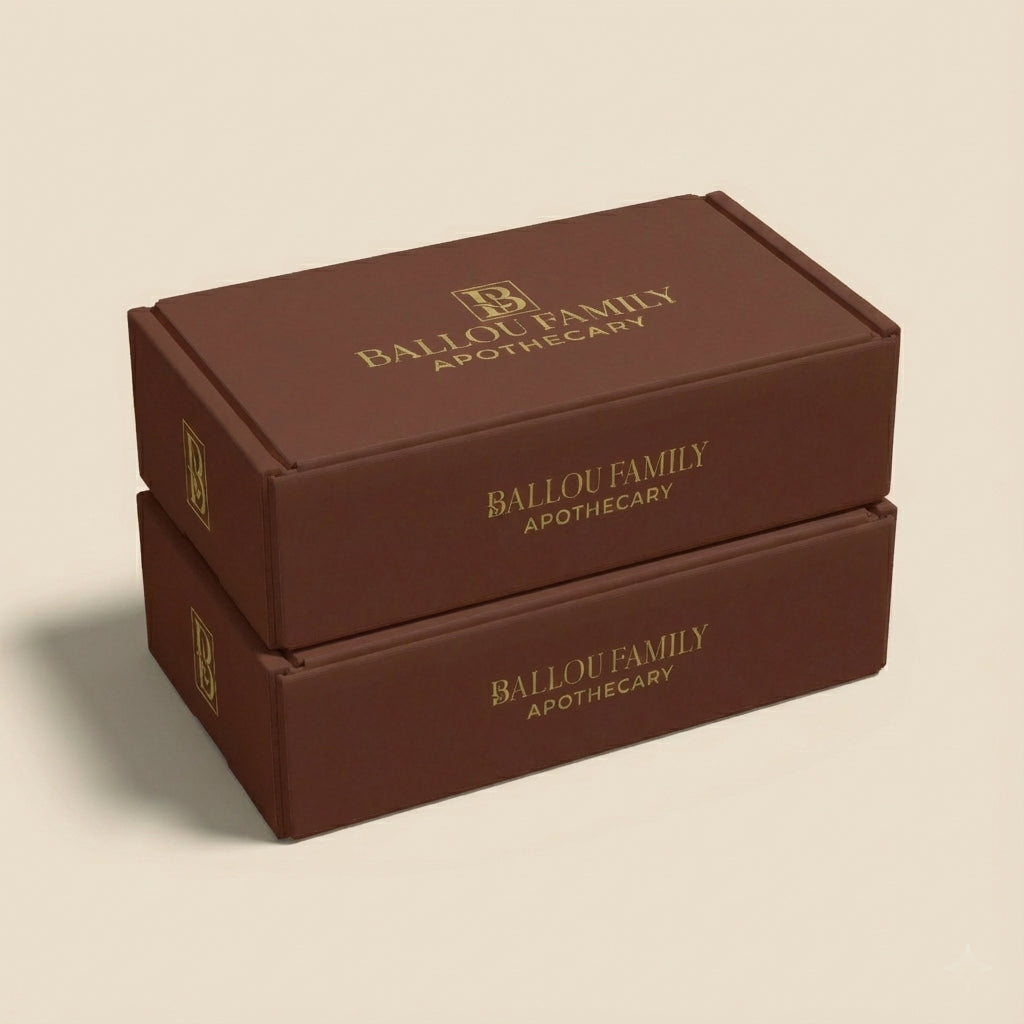 Two gift set boxes with 'Ballou Family Apothecary' branding on a beige background