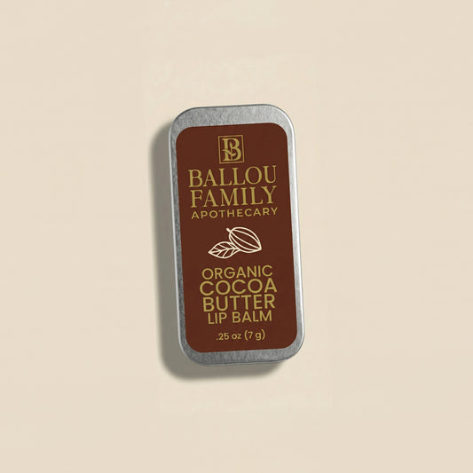 Ballou Family Apothecary organic cocoa butter lip balm tin on a beige background