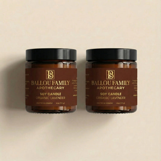 Two Ballou Family Apothecary soy candles on a beige background