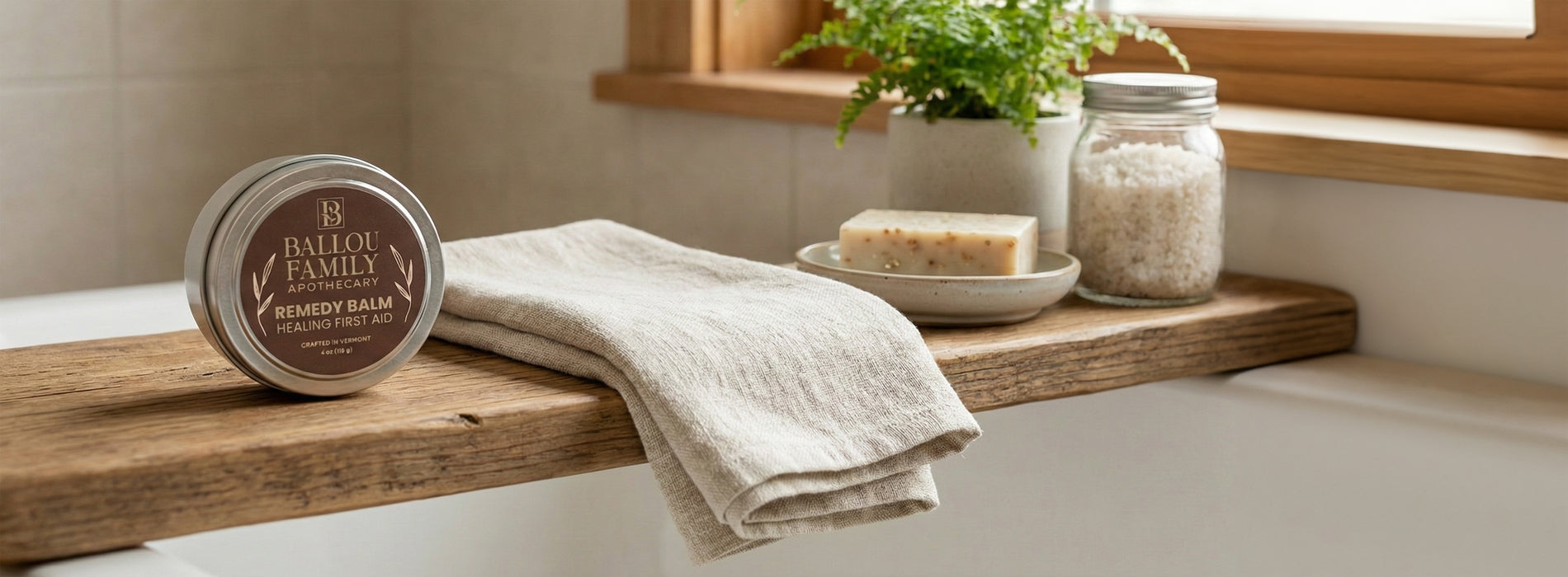 Remedy Balm and towel on a wooden shelf with a plant and jar in the background