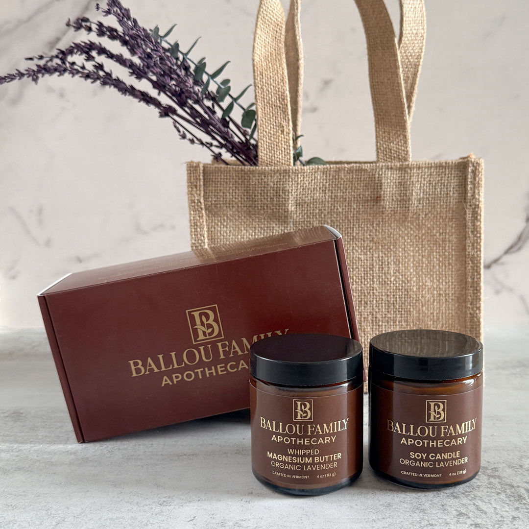 Ballou Family Apothecary products including jars and a box on a marble surface with a jute bag.