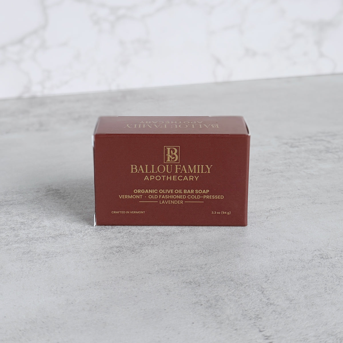 Ballou Family Apothecary soap bar packaging on a textured gray surface