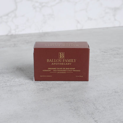 Ballou Family Apothecary soap bar packaging on a textured gray surface