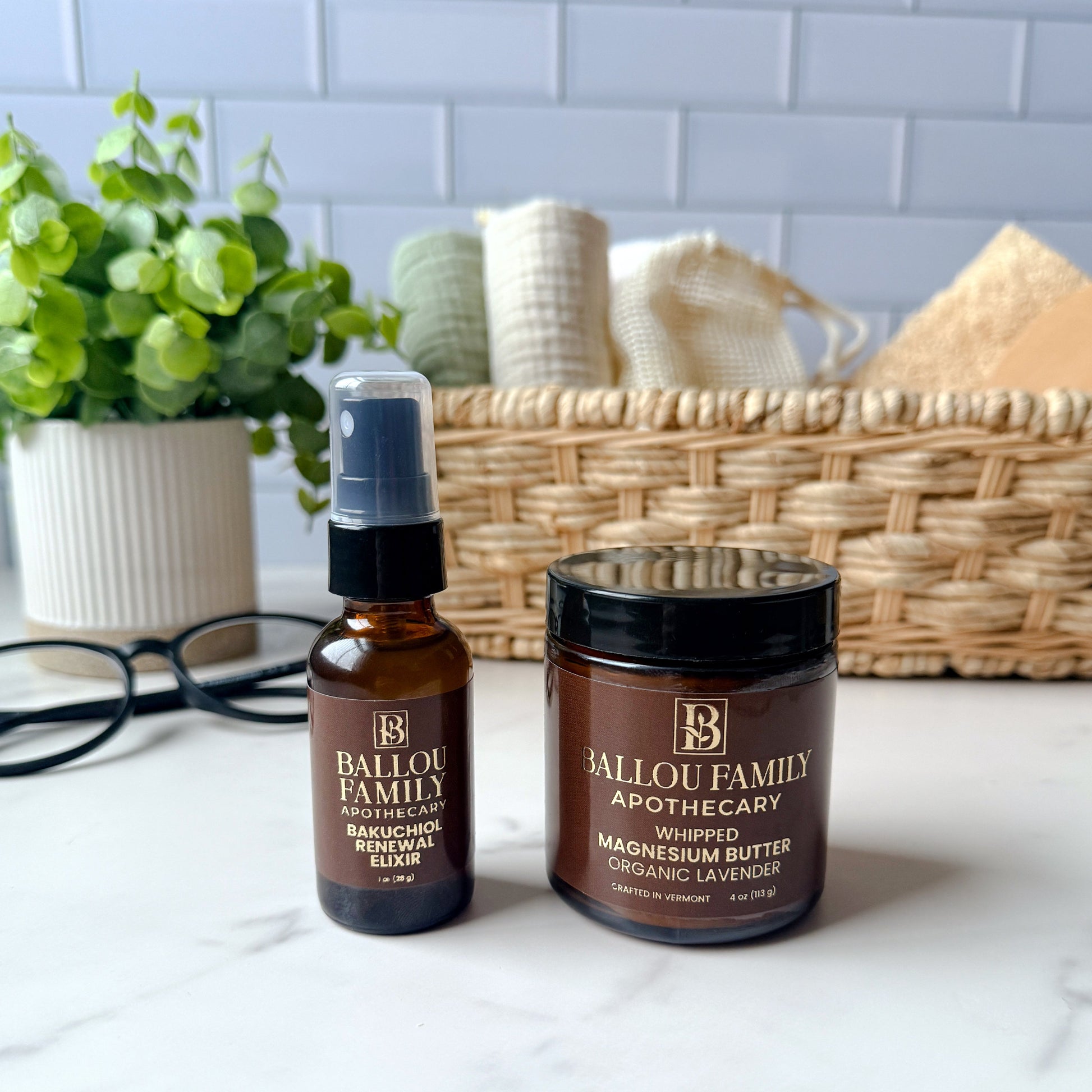Bailou Family Apothecary skincare products on a white surface with a basket and plant in the background.