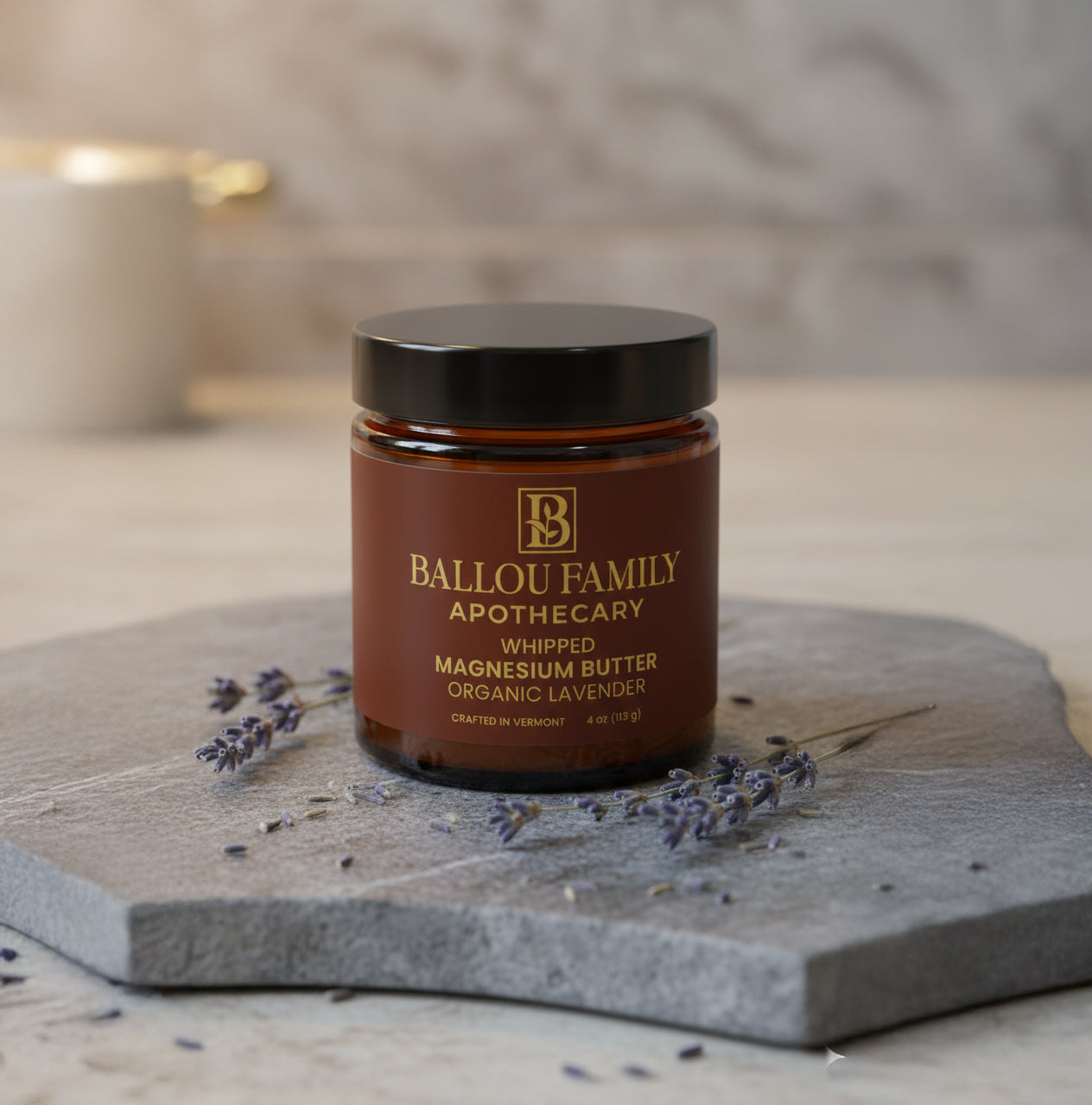 Jar of Ballou Family Apothecary whipped magnesium butter on a stone surface with lavender flowers.