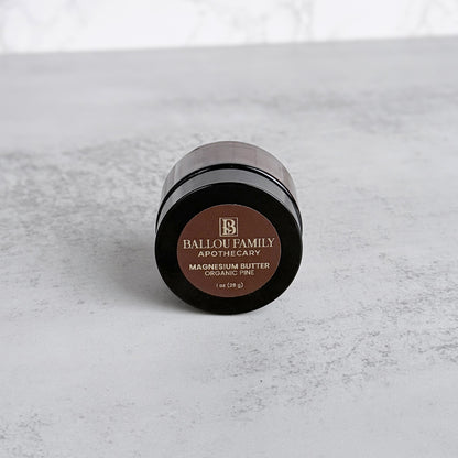 Small jar of Ballou Family Apothecary magnesium butter on a gray surface
