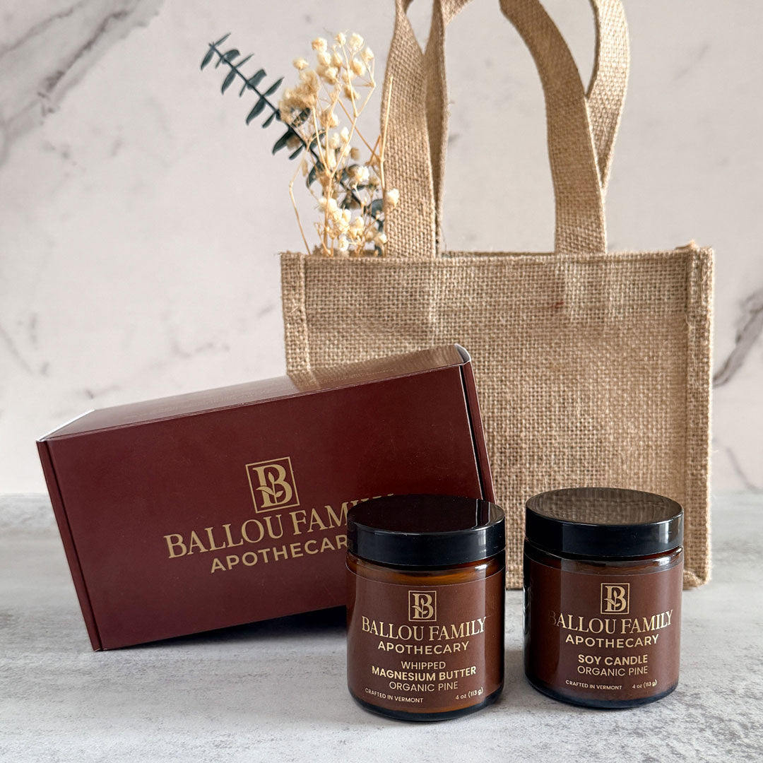 Ballou Family Apothecary products including jars and a box on a marble surface with a jute bag.