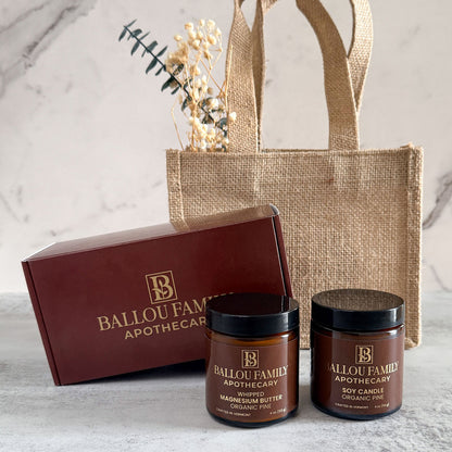 Ballou Family Apothecary products including jars and a box on a marble surface with a jute bag.