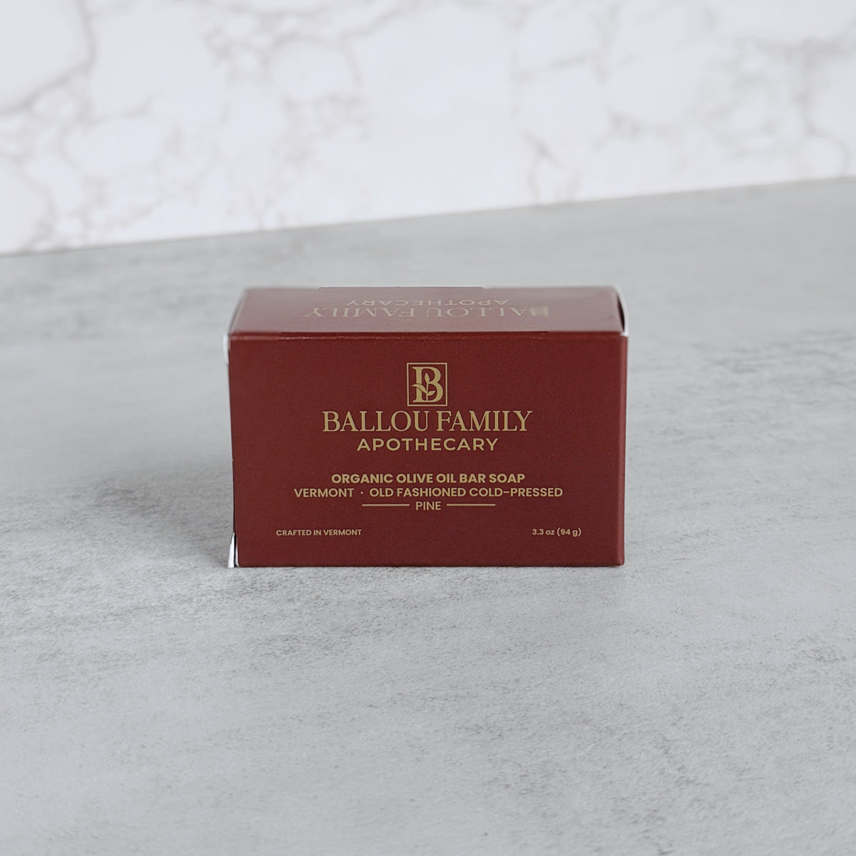 Box of pine scented soap with 'Ballou Family Apothecary' branding on a gray surface.