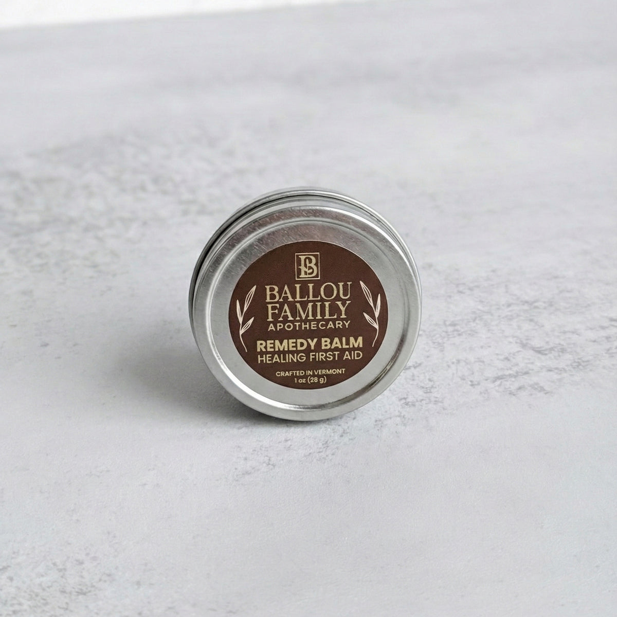 1  oz Remedy Balm tin with 'Ballou Family Apothecary' label on a light gray background