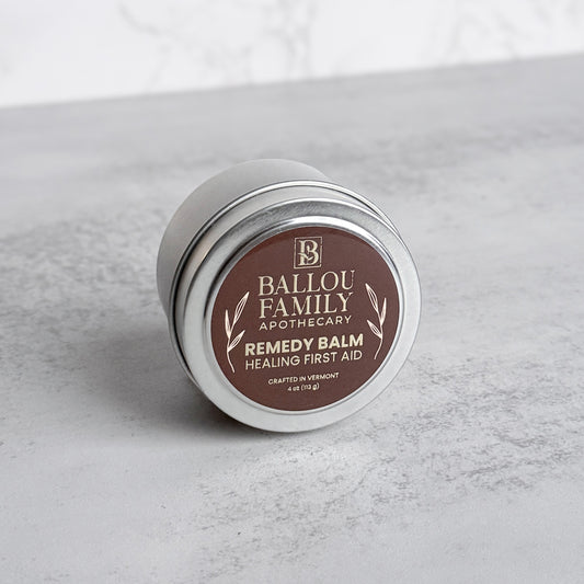 4 oz Ballou Family Apothecary Remedy Balm tin on a gray surface